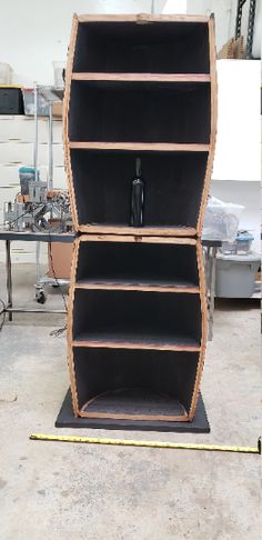 an empty book case sitting on top of a wooden shelf in a room filled with tools