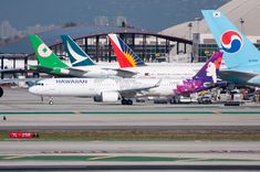 several airplanes are parked on the tarmac at an airport in front of some buildings