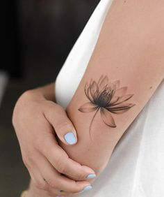 a woman's arm with a flower tattoo on the left side of her arm