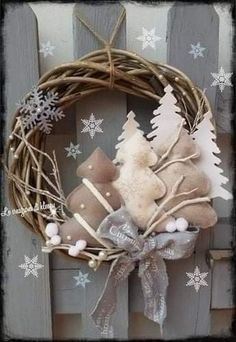 a wreath with candles and snowflakes hanging on the side of a wooden fence