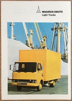 a yellow truck is parked in front of some cranes