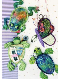 three turtle ornaments are hanging on a wall next to a purple and white striped tablecloth