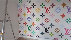 the wall is decorated with multicolored louis vuitton decals