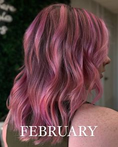 the back of a woman's head with pink hair