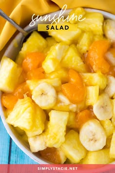 a white bowl filled with sliced bananas and oranges on top of a blue table