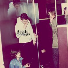 two young men standing next to each other in front of a mirror with the reflection of them