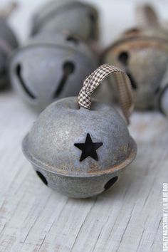 an old metal bell with a star on the top and some other bells in the background