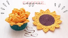 two crocheted sunflowers sitting next to each other on top of a table