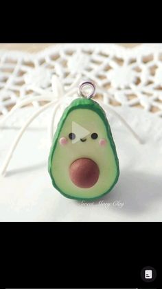 an avocado shaped keychain with a face drawn on it's side