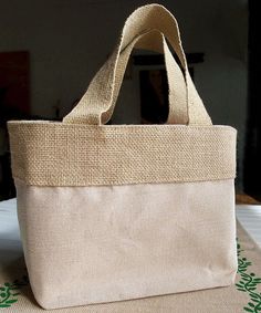 a beige bag sitting on top of a table next to a green and white cloth