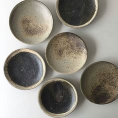 four black and white bowls sitting next to each other