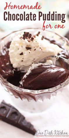 homemade chocolate pudding in a glass bowl with whipped cream on top