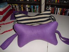 a purple pillow sitting on top of a table next to a book shelf filled with books