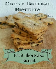 a pile of fruit shortcake biscuits sitting on top of a wooden cutting board with the words great british biscuits next to it