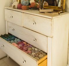 an old dresser with yarn on top