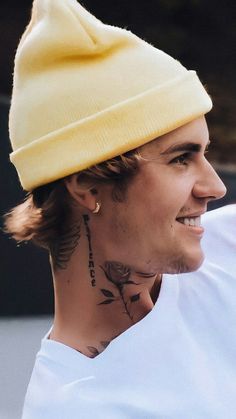 a man with a tattoo on his neck wearing a yellow hat