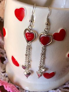 These red glass heart bead dangle earrings make a simple and delicate touch to any outfit whether you wear them for Valentine's Day or just any day. Silver-toned findings and nickel-free ear wires complete the set. Do not wear earrings when bathing or swimming. Avoid getting hairspray, perfume or lotions on them. Wipe with a soft damp cloth if required. Sterling Silver Heart Beads Dangle Earrings, Nickel-free Metal Heart Earrings For Valentine's Day, Nickel-free Dangle Earrings For Valentine's Day, Metal Heart Beaded Earrings For Gifts, Metal Heart Beads Earrings For Gifts, Heart Beads Metal Earrings For Gift, Valentine's Day Nickel-free Dangle Earrings, Gift Metal Heart Earrings With Heart Beads, Valentine's Day Dangle Earrings With Dangling Charms