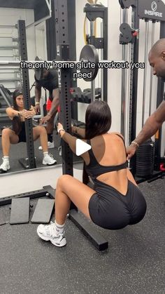 a woman squatting on a bench in front of a mirror while another man watches