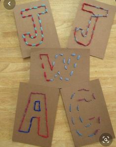 four pieces of cardboard with letters drawn on them