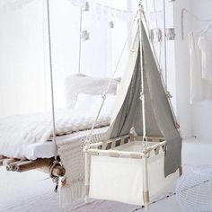 a white bed with a gray tent hanging from it's side