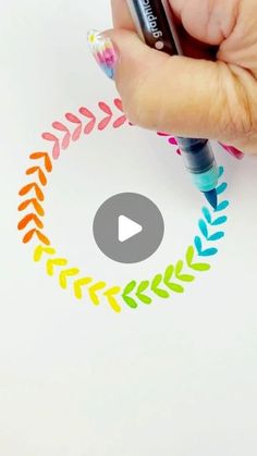 someone is drawing with colored markers on paper