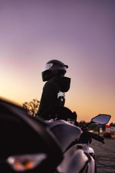 a person sitting on a motorcycle at sunset