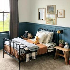 a bedroom with a bed, table and two stuffed animals on the side of it