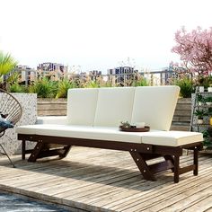 an outdoor lounge chair sitting on a wooden deck