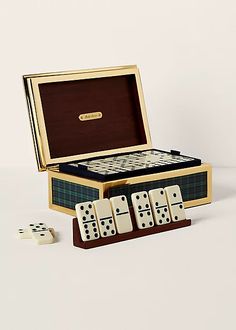 an open wooden box with four dices and one set of dominos in it