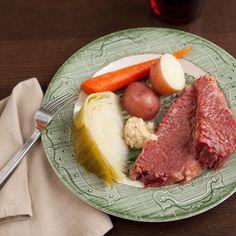 a plate with meat, potatoes and carrots on it next to a glass of wine