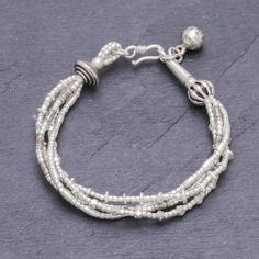 Four strands of 950 silver beads in complementary but varying patterns are twisted together to make this bracelet from Thailand's Pakaon Sojintarit. Where the ends meet a silver hook clasp is accented by a hand-stamped silver ball charm. Areas of oxidization add to the textural beauty of this piece. Karen hill tribe silver is made using techniques that have been passed down through families for generations in Thailand using only hand tools. Beaded Charm Bracelet, Floral Cuff, Silver Beaded Bracelet, Silver Elephants, Hill Tribe Silver, Silver Bead Bracelet, Elephant Charm, Bead Charm Bracelet, Hook Clasp