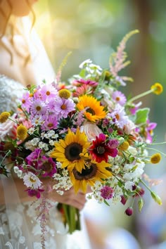 a bride holding a bouquet of flowers in her hands with sunlight shining through the background