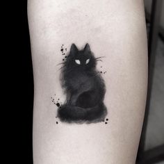 a black cat tattoo on the left thigh