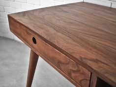 a close up of a wooden table with two holes in the top and one drawer