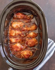 the slow cooker is full of chicken legs with sauce in it and text that reads, 5 ingredient slow cooker chicken legs