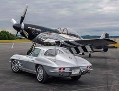 an old car is parked next to a small airplane