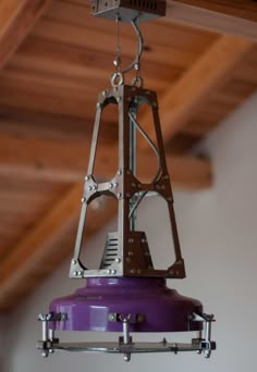 a light fixture hanging from the ceiling in a room with wood beams and rafters