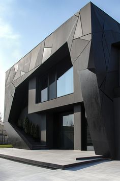 a modern building with an unusual design on the front and stairs leading up to it