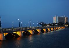 a bridge that is over water with lights on it