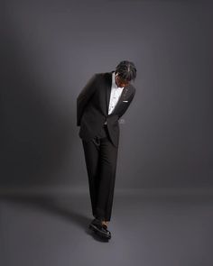 a man in a tuxedo is leaning on his head