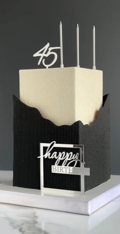 a black and white birthday cake with candles