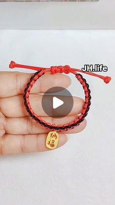 a person holding a red string bracelet