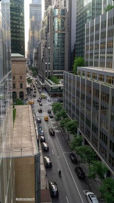 a city street filled with lots of traffic next to tall buildings in the middle of the day