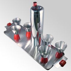 a metal tray with cups and spoons on it