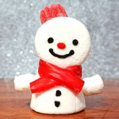 a small white snowman with a red scarf around its neck