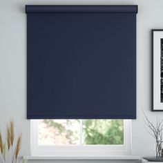 a blue roller blind in a living room with pictures on the wall and windowsill