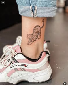 a woman's foot with a cat tattoo on it