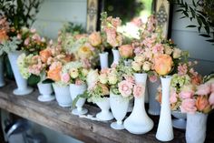 many white vases filled with different types of flowers