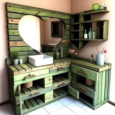 a bathroom with green wooden cabinets and a white sink under a large mirror on the wall