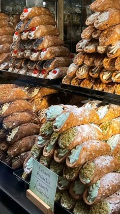 many different kinds of pastries on display in a store